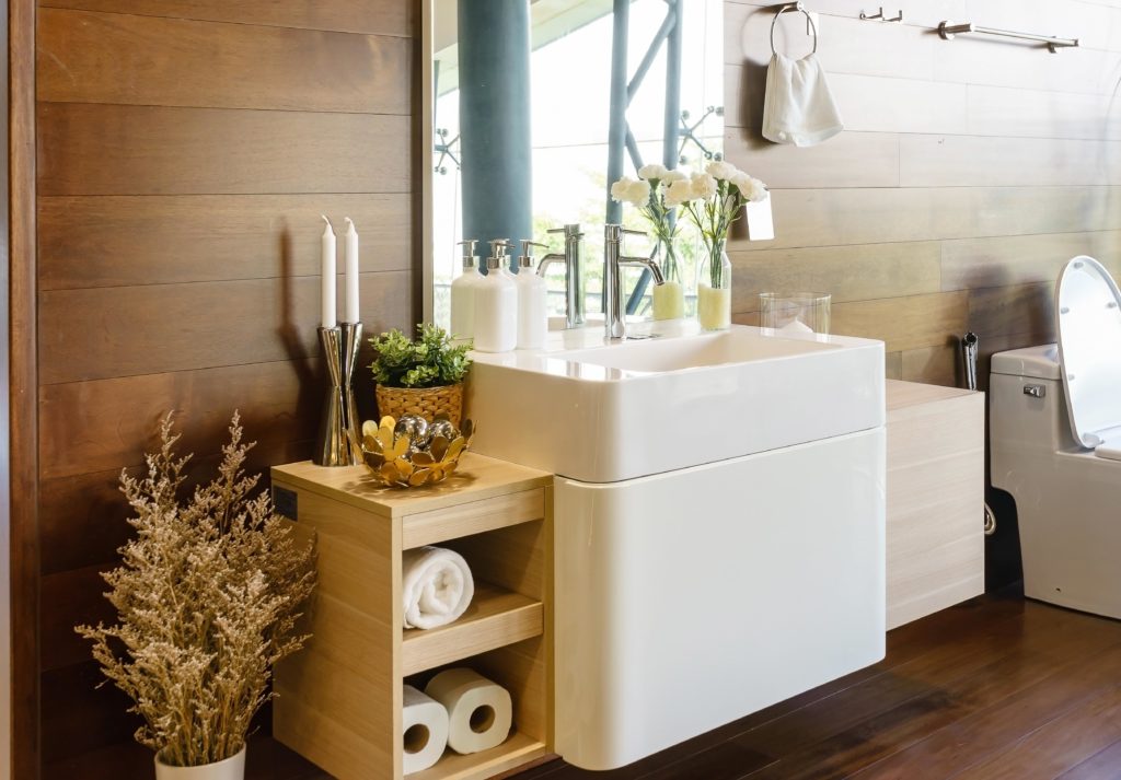 Modern spacious bathroom with bright tiles with toilet and sink. Side view