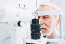 Senior man getting eye exam at clinic, close-up